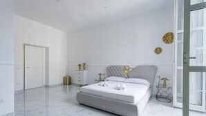 A modern bedroom with a large bed, a bedside table, and a nightstand. - Golden Suites Golden room by Dimorra (NAPOLI)