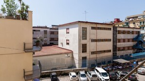A multi-story building with a parking lot in front. - Metro Station By Dimorra (Napoli)