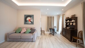 Un salon moderne avec un canapé, une table à manger et un meuble.