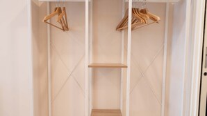 Un placard avec des cintres et des étagères en bois.