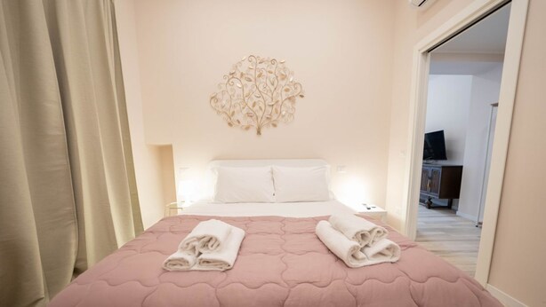 Une chambre d’hôtel avec un lit, un élément décoratif mural et une vue sur le couloir.