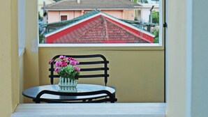 Un balcon donnant sur un bâtiment aux toits rouges, avec un plan d’eau en arrière-plan.