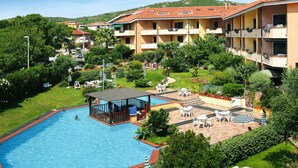 A hotel with a swimming pool, outdoor seating, and a garden area. - Li Velieri 6 pax Pool & Private Garden (Santa Teresa Gallura)
