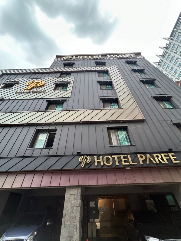 Ein modernes Hotel mit einem gut sichtbaren 'HOTEL PARFE' Schild an der Fassade.