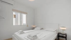 A minimalist bedroom with a large bed, two bedside tables, and a window. - Bright Rooftop in Fuengirola City Center by Costarentals - Ref 255 (Fuengirola)