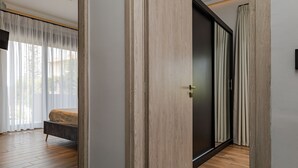 Ein modernes Schlafzimmer mit einem Bett, Holzboden und einer Schiebetür.