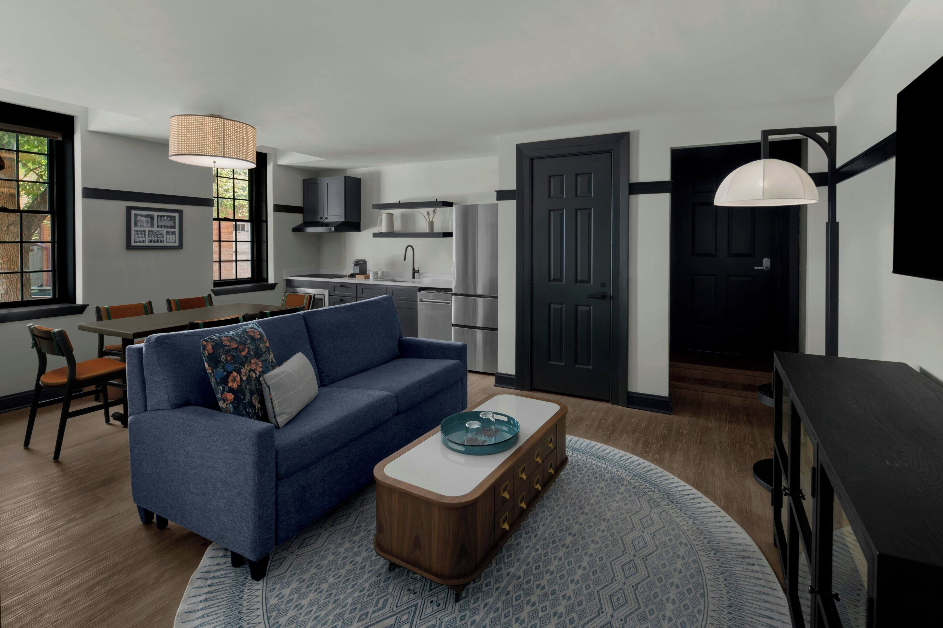 A modern living room with a sofa, coffee table, and dining area.