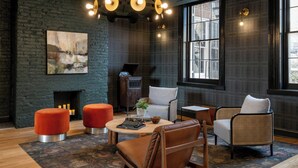 A modern living room with a fireplace, comfortable seating, and large windows. - Visitation Hotel Frederick, a Tribute Portfolio Hotel (Frederick)