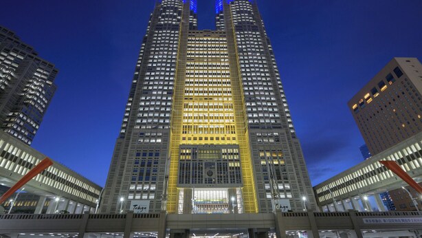 A high-rise building with a prominent central section highlighted in yellow, surrounded by other buildings. - BE Terrace Nishi-Shinjuku _Shinjuku Area / 5 min. walk from Nishi-Shinjuku Station 6 min. from Shinjuku Station (新宿区)