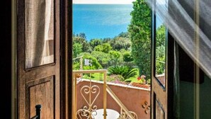 A view from a balcony with a metal railing, overlooking a lush garden and the sea. - B&B La Torretta - Double Room with Sea View (Cersuta)