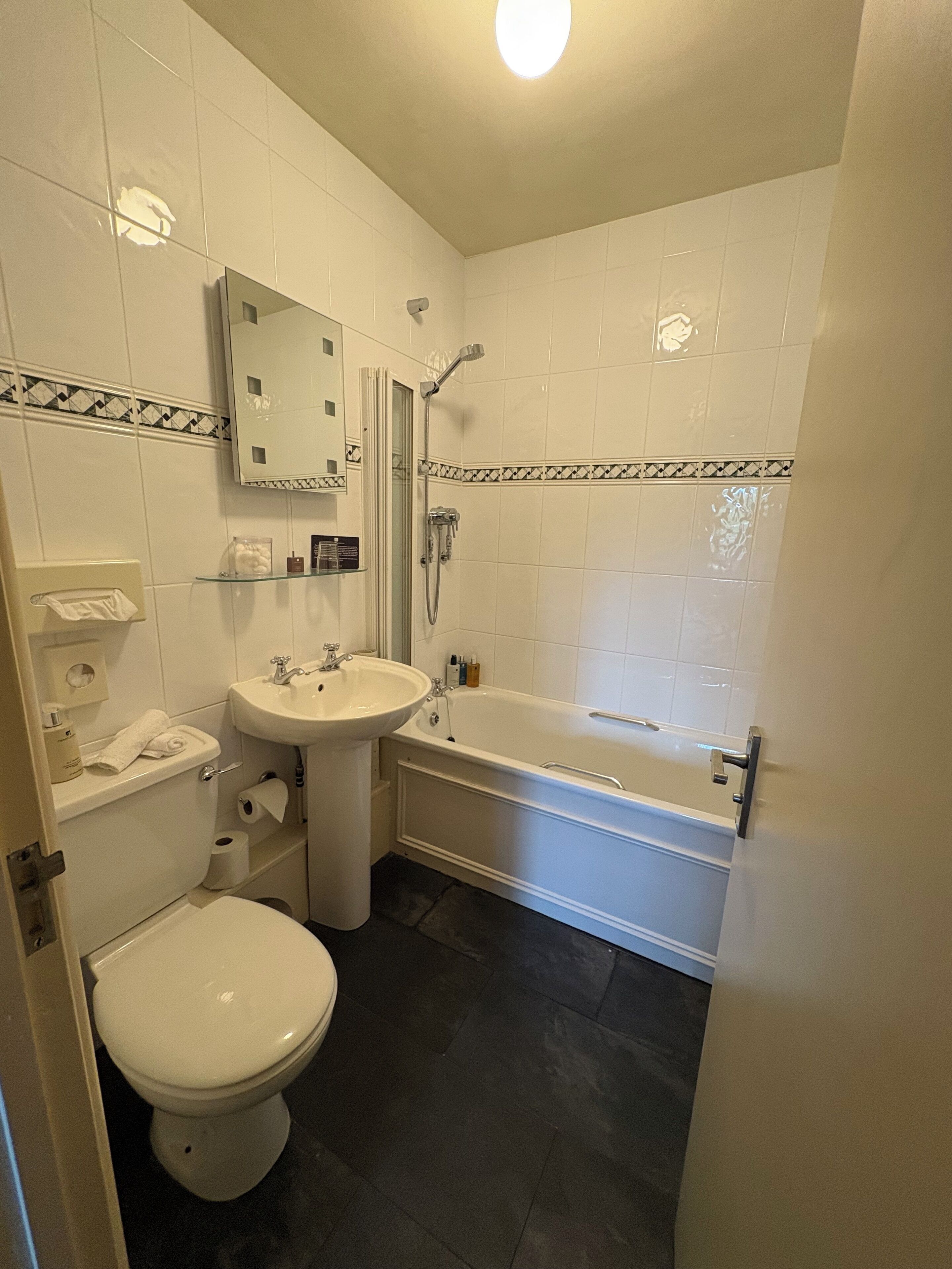 A bathroom with a toilet, sink, and bathtub.