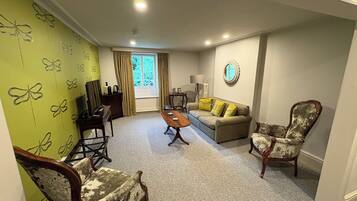 Deluxe Suite, Valley View | Living area | 32-inch Smart TV with digital channels, books