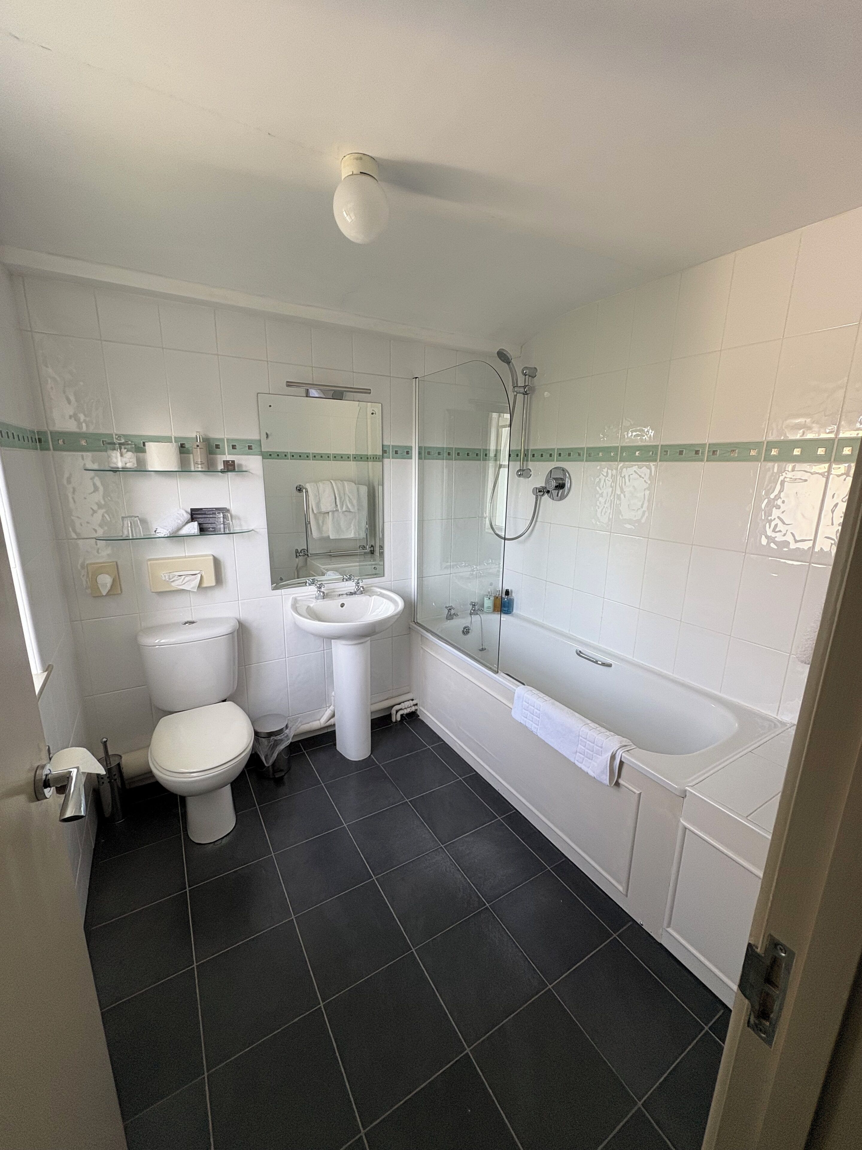A bathroom with a toilet, sink, and bathtub.