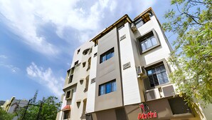 A multi-story building with a flat facade, several windows, and a sign reading "Atithi". - Hotel Atithi - Opposite Shreeji Hospital (Rajkot)