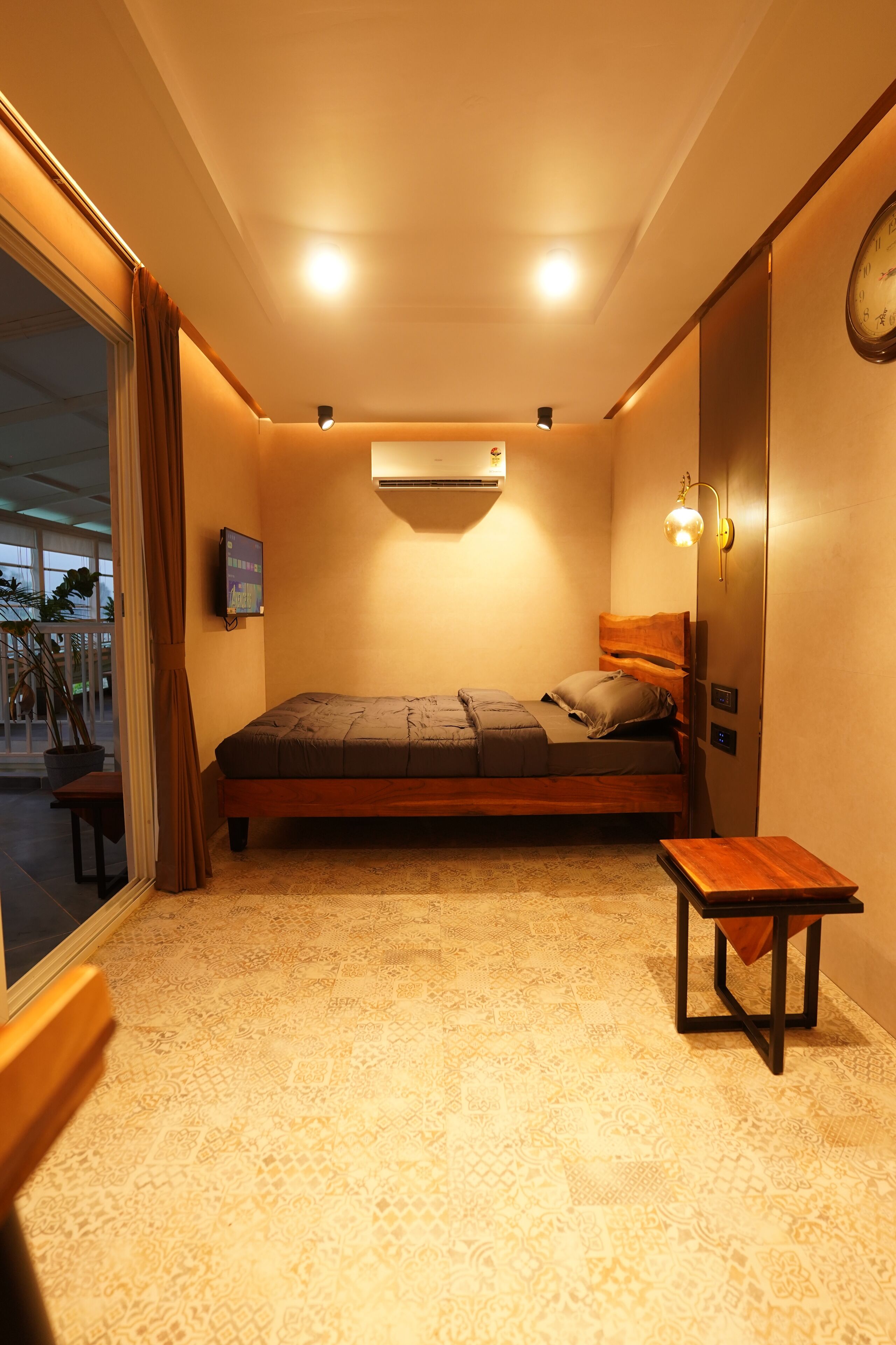 Une chambre à coucher de taille réduite, comprenant un lit, une petite table et une horloge fixée au mur.