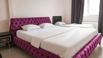 Una cama doble con cabecera capitonada en una habitación de hotel.