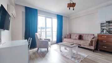 Condo estándar, balcón | Área de sala de estar | Televisión