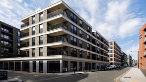 A multi-story building with balconies, large windows, and a flat facade. - Boho-Chic Escape, by Veeve (London)