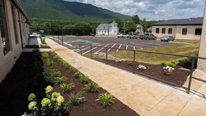 Un parking avec un bâtiment sur la gauche, une église en arrière-plan et une montagne.