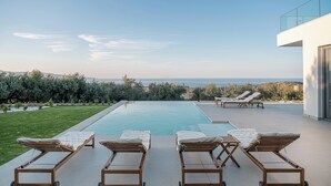 A modern pool area with lounge chairs and a clear view of the sea. - Villa Zefyros With Sea View (Platanias)