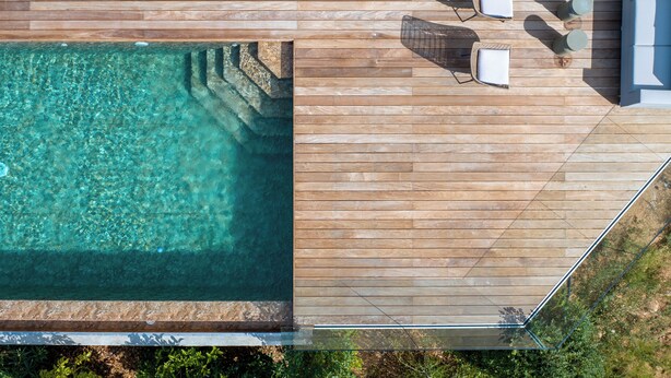 An aerial view of a wooden deck with a swimming pool, outdoor seating, and a glass balustrade. - SUMPTUOUS MODERN VILLA (Pietrosella)