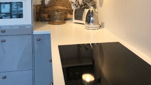 Una cocina con estufa, horno y un reloj en la pared.