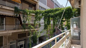 Um edifício com vários andares e varandas, algumas com plantas.