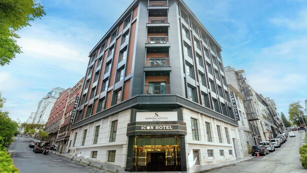 A multi-story hotel with a prominent entrance, balconies, and a clear sky. - İcon Hotel Bomonti (Istanbul)