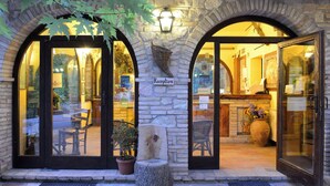 A reception area with a stone facade, wooden bench, and potted plants. - Cozy three-room apartment in the Umbrian countryside. (Umbria)