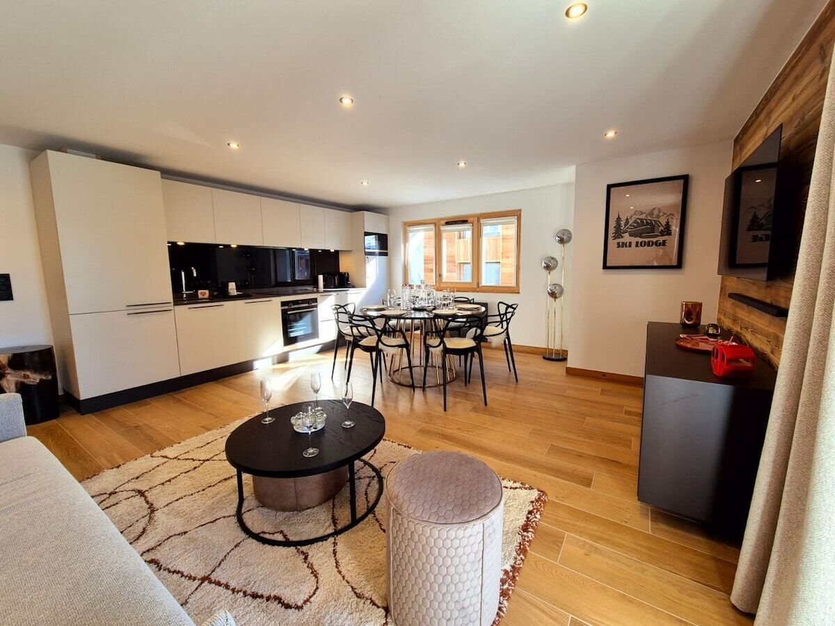 A modern kitchen with white cabinets and a dining area with a round table and chairs.