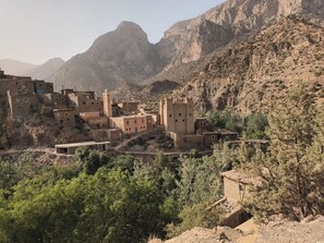 A village with traditional buildings and a prominent castle-like structure. - Ighrem Le Grenier (Tabant)