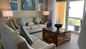 Ein Wohnzimmer mit einer Couch, Sesseln, einem Couchtisch und Kunstwerken an der Wand.