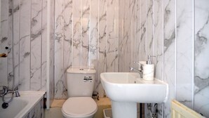 Ein Badezimmer mit Toilette, Waschbecken und Dusche.