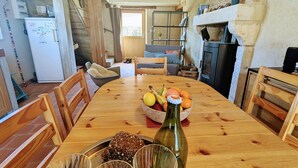 A wooden dining table with a bowl of fruits, a bottle, and glasses. - Two Berry houses with private garden and shared courtyard, perfect for groups (Thenay)