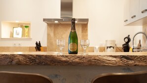 Una encimera de cocina con una botella de champán y dos copas.