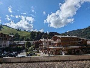 Ein Hotel mit mehreren Stockwerken, einem Parkplatz und einer Bergkulisse.