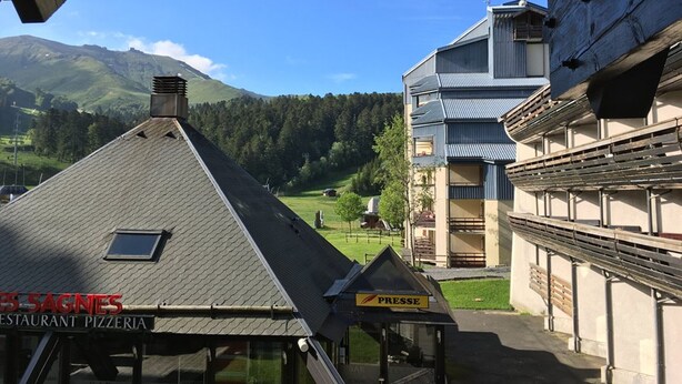 A restaurant named 'SAGNES' with a view of a mountainous landscape.