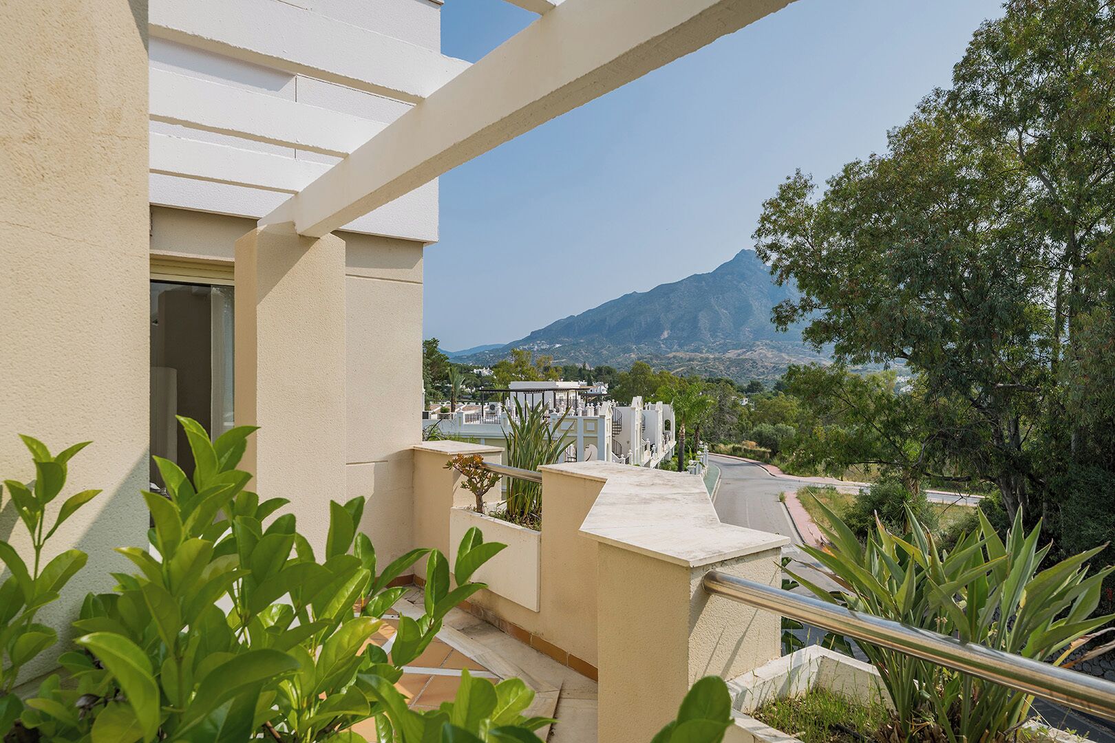 Een balkon met uitzicht op een berg en een stad.
