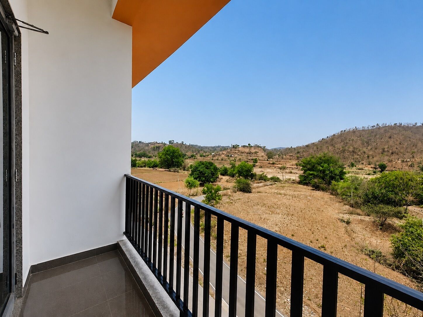 Un balcón con vistas a un paisaje seco y montañoso.