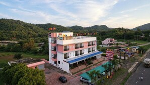 Un hotel de varios pisos con terraza en la azotea, piscina y restaurante.