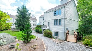 A two-story house with a gravel driveway, wooden steps, and a small wooden deck. - Top of 7, B-10- Close to Boone & Banner Elk, Mtn View, Fireplace, Cute & quaint (Seven Devils)