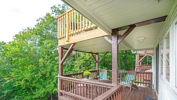 A wooden deck with a railing, a table with chairs, and a small garden area. - Top of 7, B-10- Close to Boone & Banner Elk, Mtn View, Fireplace, Cute & quaint (Seven Devils)