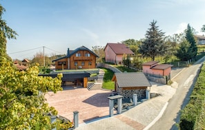 Un barrio residencial con una casa grande de madera, una casa más pequeña y una construcción de piedra.