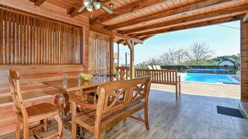 Enjoy dining al fresco on the covered patio with a ceiling fan overhead, steps from the pool.