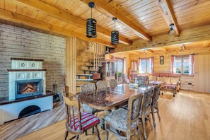 Ein gemütliches Holzinterieur mit Kamin, Esstisch und Stühlen.