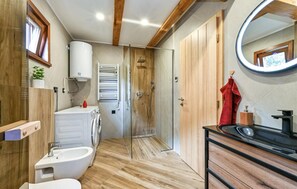 A modern bathroom with a wooden floor, a white sink, a glass shower enclosure, and a wooden wardrobe. - Luxury Villa in Vinogradi Ludbreski (Ludbreg)