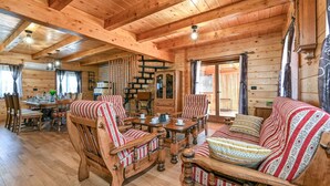 Ein Holzblockhaus mit Essbereich, einer Couch und einem Schrank.