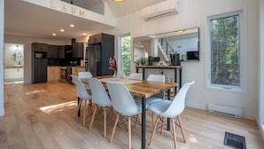 Een moderne keuken met een eethoek, bestaande uit een houten tafel en lichte stoelen.