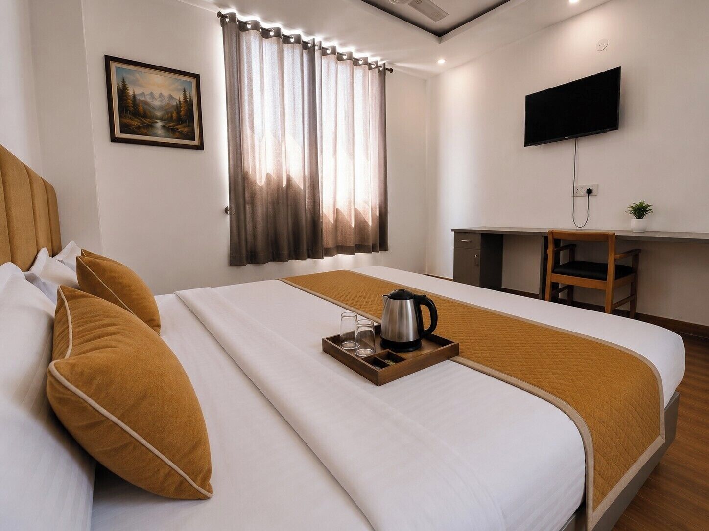 A hotel room with a bed, a desk, a television, and a painting on the wall.