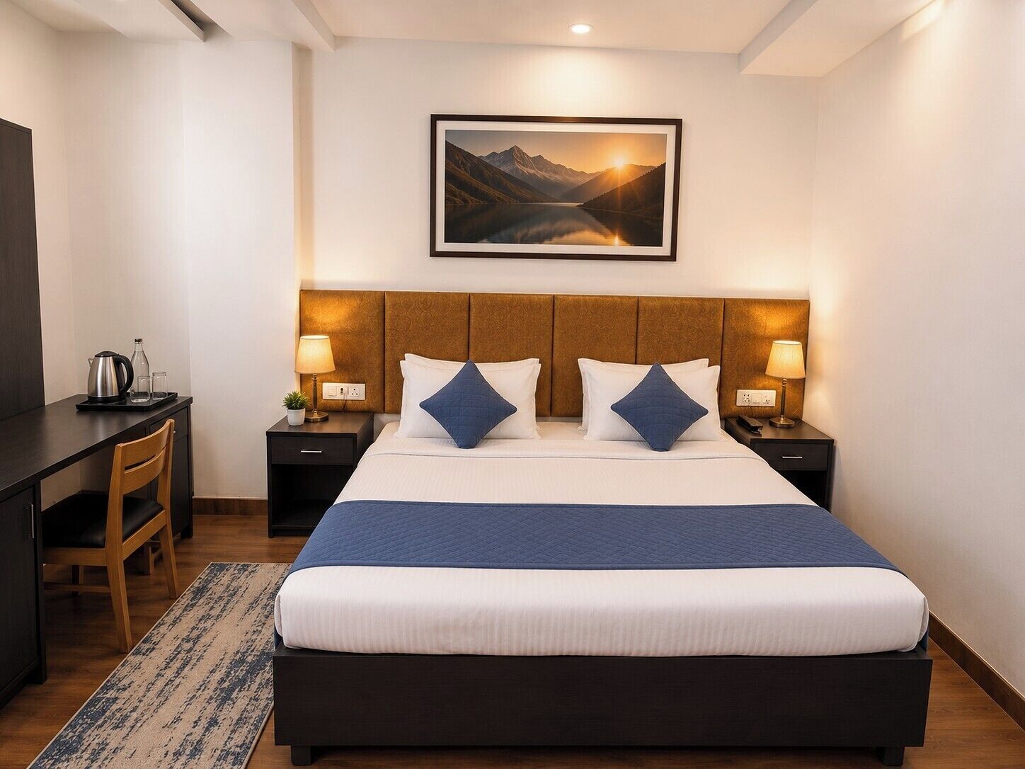 Ein Hotelzimmer mit Bett, Nachttischen, einem Schreibtisch und einem Sessel.